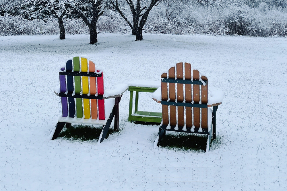 photo of a brightly colored chair looking out at a snowy scene