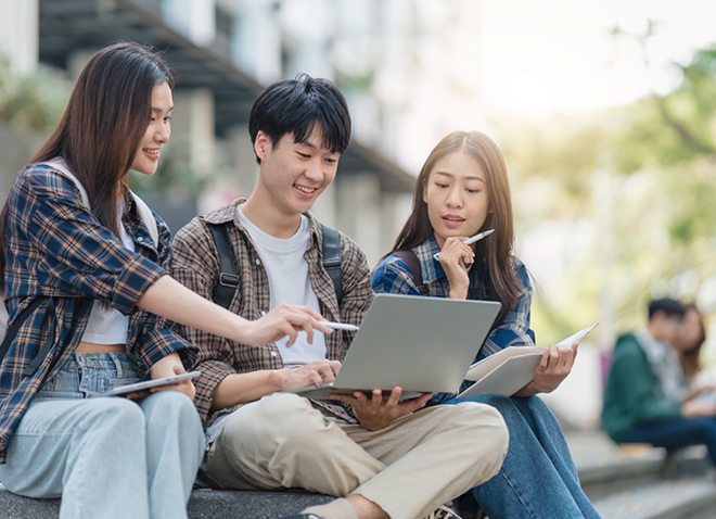 Photo of three young Asian American college students studying together on campus