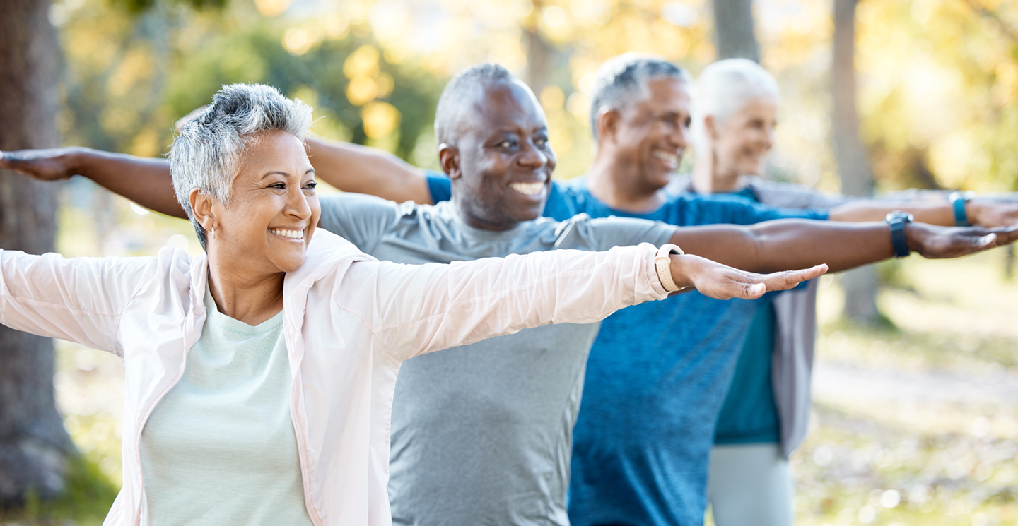 a group of senior people in an outside yoga class