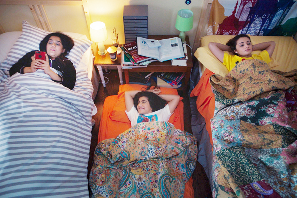 a still photo from the movie Americanish showing three young Muslim women in their beds chatting with each other